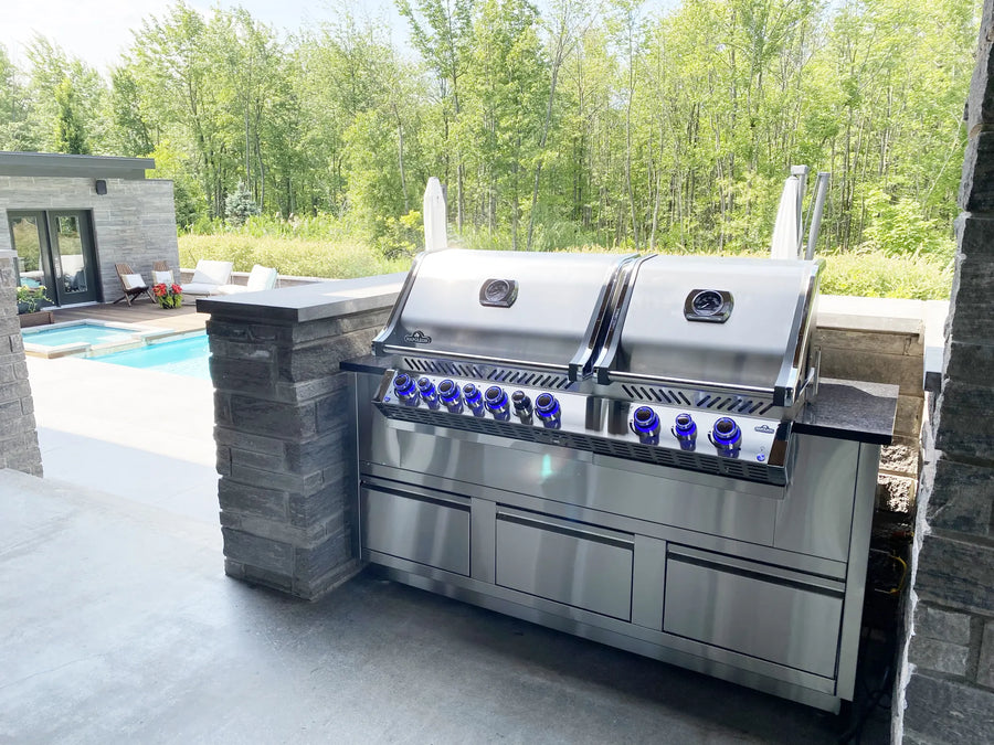 Îlot de cuisine extérieure Cuinox sous une pergola près de la piscine