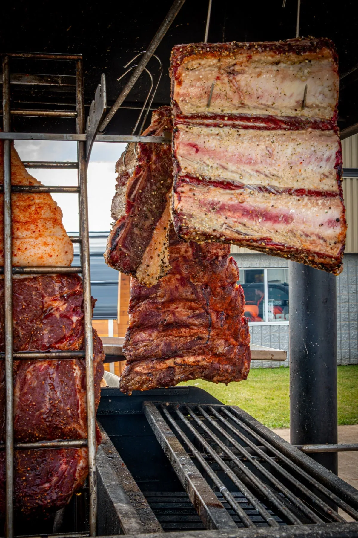 Viandes suspendues au-dessus des braises sur l'asado, Party BBQ Nation 2026